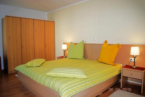 a bedroom with a bed with yellow and green pillows at Strandoase-Whg-13 in Heringsdorf