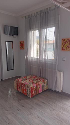 Bett in einem Zimmer mit einem großen Fenster in der Unterkunft MAJA HOUSE 2 in Skala Potamias