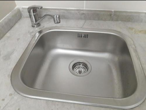 a stainless steel sink with a faucet in a kitchen at Dar Janis Djerba دار يانيس جربة in Houmt Souk