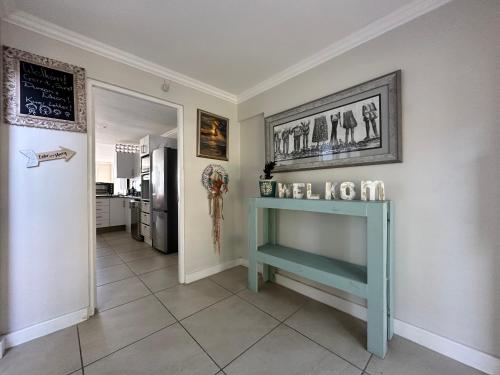 a hallway with a blue table and a kitchen at Allalapstix in Reebok