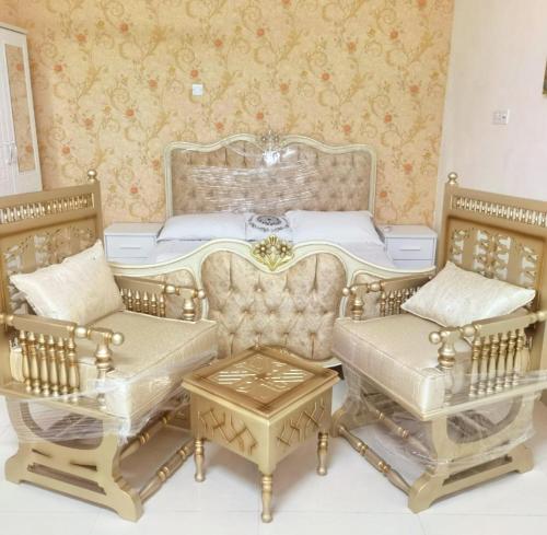 a room with a bed and two chairs and a table at شالية البندرvip in Ḩifrī