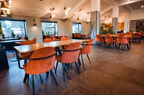 un comedor con mesas y sillas en un restaurante en Pensiunea Oscar, en Campina