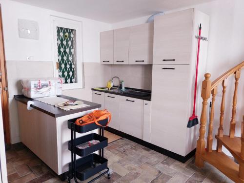 a small kitchen with white cabinets and a counter at Casa ORI in Perledo