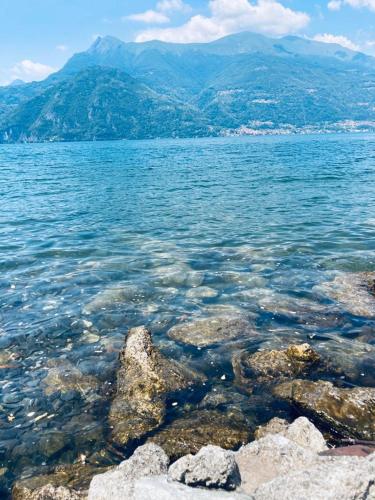 a large body of water with rocks and mountains at Casa ORI in Perledo