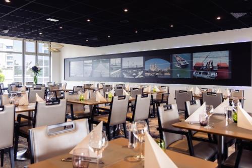 a dining room with wooden tables and chairs at Mercure Paris Ivry Quai De Seine in Ivry-sur-Seine