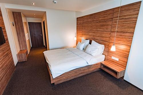 a bedroom with a large bed with a wooden headboard at Hotel Oscar in Campina