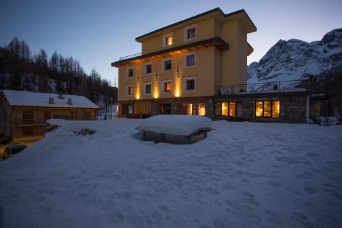 un grande edificio nella neve di notte di Apartments Suites LAC BLEU a Breuil-Cervinia
