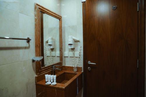 Nour Al Thuria Hotel في مكة المكرمة: حمام مع حوض ومرآة