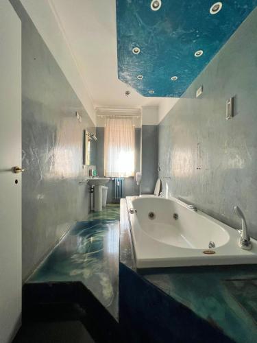 a bathroom with a bath tub with a blue ceiling at APPARTME Guest House Seveso 40 in Milan