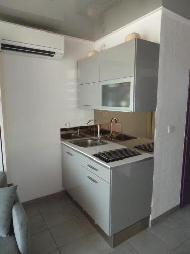 uma cozinha com um lavatório e um fogão forno superior em le select em Cap d'Agde