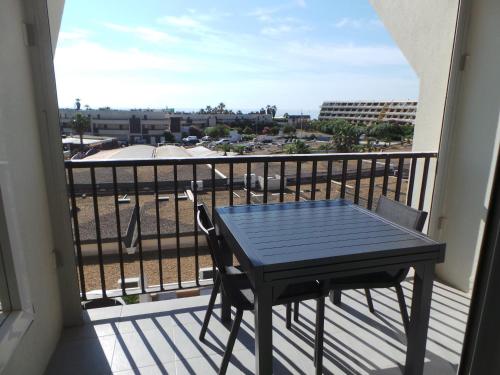 une table et des chaises noires sur un balcon avec vue dans l'établissement le select, au Cap d'Agde