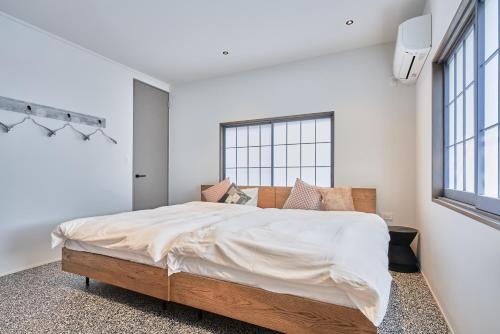 a bedroom with a large bed and a window at No3 Tsuchiura CYCLE HOME HOTEL in Tsuchiura