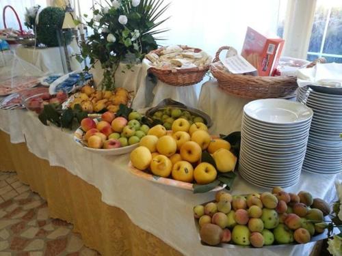 a table with baskets of fruits and plates on it at Hotel Holiday Sul Lago in Bolsena