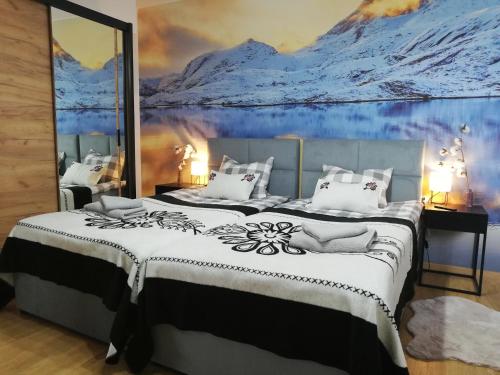 1 dormitorio con 2 camas y un mural de montañas en Apartament Grapa 29 K3 na terenie Sun & Snow Białka Tatrzańska, en Białka Tatrzanska