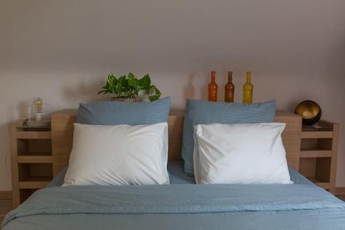 a bed with blue sheets and white pillows at Les jardins du Quesnoy - 25min de Pairi Daiza in Blicquy
