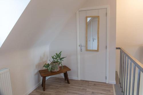 a hallway with a door and a table with a mirror at Les jardins du Quesnoy - 25min de Pairi Daiza in Blicquy