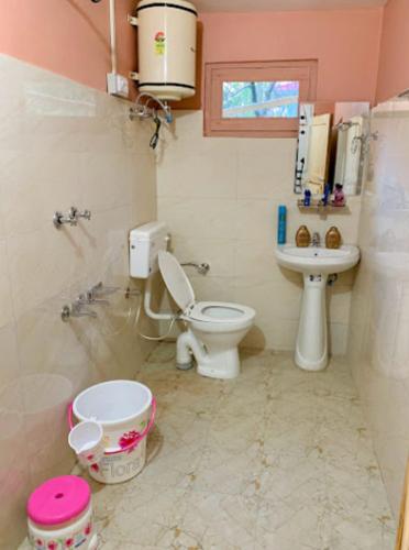 a bathroom with a toilet and a sink at RRR COTTAGES AND TREE HOUSE BY WB RESORTS in Banjār