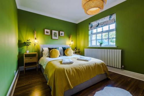 a bedroom with green walls and a bed with yellow sheets at Perfect 3 Bedroom Home for family or business stay in Chester