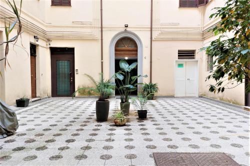 een binnenplaats met potplanten voor een gebouw bij Bellezza Al Colosseo - B&B & Apts in Rome