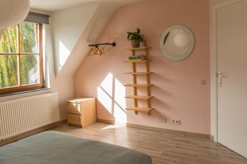 a room with a staircase and a window and a shelf at Les jardins du Quesnoy - 25min de Pairi Daiza in Blicquy