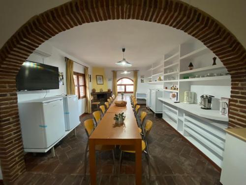 an archway in a kitchen with a long table and chairs at Casas Rurales Monasterio de Rocamador in Almendral