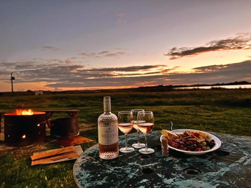 a table with two glasses of wine and a plate of food at Coorong Island Retreat - Farm Stay at Pet Friendly Property in Meningie