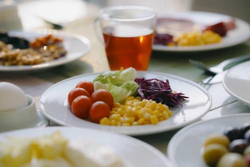 Una mesa con platos de comida y un vaso de cerveza. en Nour Althuria Hotel - Elaf Almaqam, en La Meca