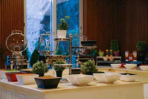 a table with bowls and potted plants on it at Nour Althuria Hotel - Elaf Almaqam in Makkah