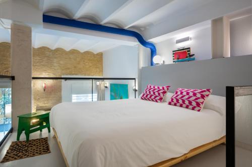 1 dormitorio con 1 cama blanca grande con almohadas rosas en CSE San Bernardo, en Sevilla