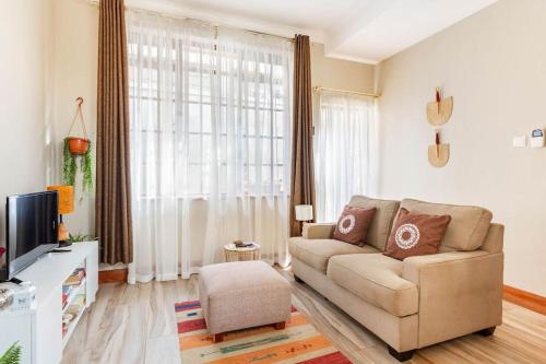 un soggiorno con un divano e una TV di Gorgeous Well Equipped Modern Guest House in Loresho a Nairobi