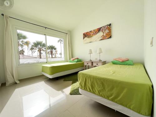 1 dormitorio con cama verde y ventana grande en Island Village en Adeje