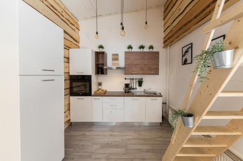 a kitchen with white cabinets and wooden floors at Apartments Keber in Ljubljana