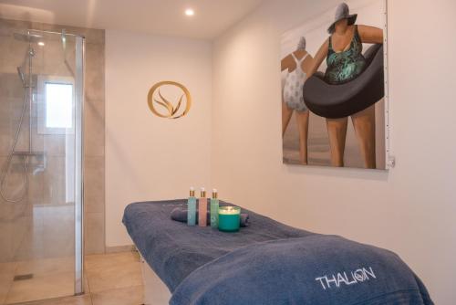 La salle de bains est pourvue d'un lit de massage et d'une douche. dans l'établissement Hôtel Sport & Spa, Ile d'Ouessant, The Originals Collection, à Lampaul