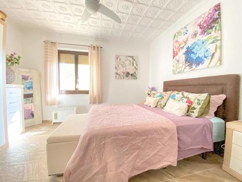 a bedroom with a large bed with a pink blanket at Casa Senna in Alicante