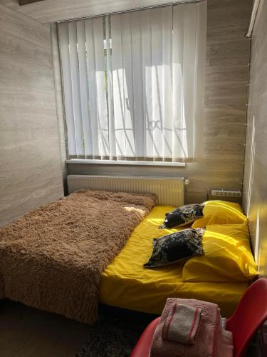 a bedroom with a bed with yellow sheets and a window at Apartment centru Chisinau in Chişinău
