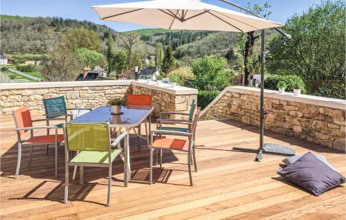 a table and chairs with an umbrella on a deck at Stunning Home In Coly With Wifi in Coly