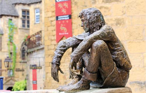 a statue of a man sitting on a bench at Stunning Home In Coly With Wifi in Coly