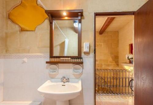 ein Bad mit einem Waschbecken und einem Spiegel in der Unterkunft Gozitan Farmhouse Pool & Jacuzzi - PP 2 in Il-Wilġa