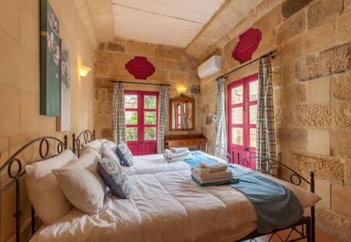 ein Schlafzimmer mit einem großen Bett in einem Zimmer in der Unterkunft Gozitan Farmhouse Pool & Jacuzzi - PP 2 in Il-Wilġa