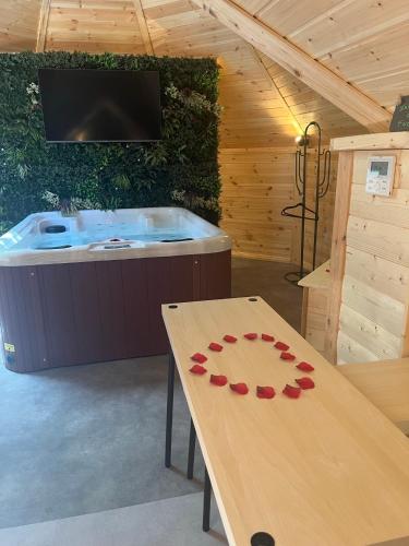 a wooden table in a room with a hot tub at Les hebergements Insolites in Taradeau