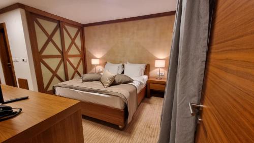 1 dormitorio con 1 cama y escritorio con 2 lámparas en Apartman B428 Vucko, en Jahorina