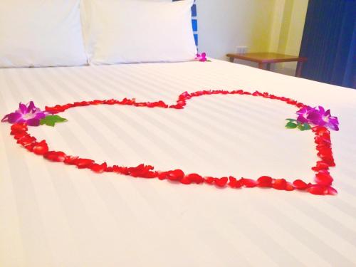 a bed with a heart made out of flowers at Glitter House Phuket in Kata Beach