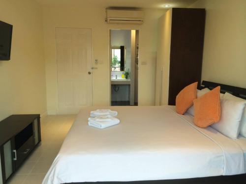 een slaapkamer met een groot wit bed en handdoeken bij Glitter House Phuket in Kata Beach