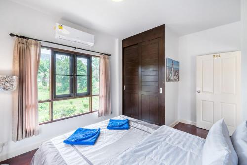 ein Schlafzimmer mit einem großen Bett mit blauen Kissen darauf in der Unterkunft Sea eagle pool villa in Ao Nang Beach