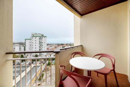 uma varanda com uma mesa e cadeiras brancas e uma janela em Equador Superior Suites by Olala Homes em Cascais