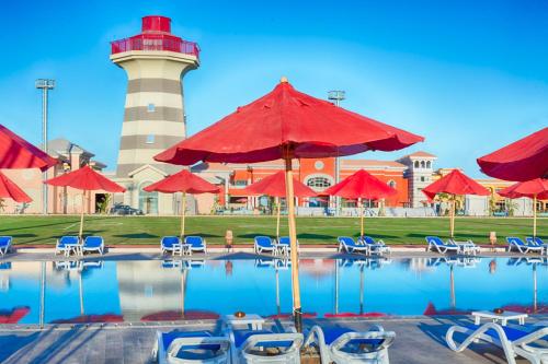 Porto Sharm Hotel Apartments Delmar for touristic investment في شرم الشيخ: منور مع كراسي ومسبح مع منور