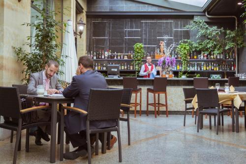 two men sitting at a table in a restaurant at Hotel Bardo Recoletos Coco in Salamanca