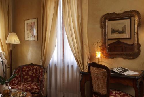 a room with a chair and a table and a window at Hotel Bisanzio in Venice