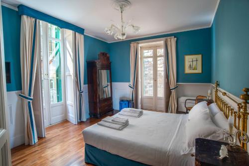 a bedroom with blue walls and a bed with white sheets at I Sogni della Memoria in Ragusa