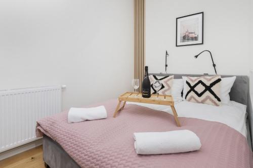 Gdańsk Vespa Apartment by Renters في غدانسك: غرفة نوم بسرير مع وسادتين وطاولة